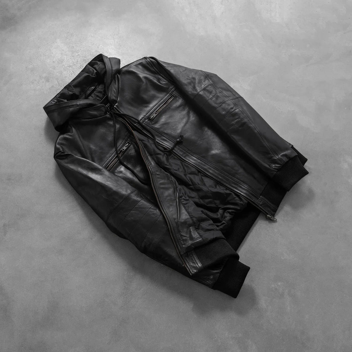 
Perspetiva vestida de Bouncer Biz Black Leather Hooded Bomber Jacket no modelo com caimento natural à luz do dia